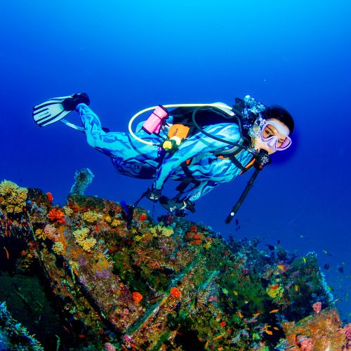 Scuba diver exploring a colorful coral reef underwater with BOLDE steam wetsuit
