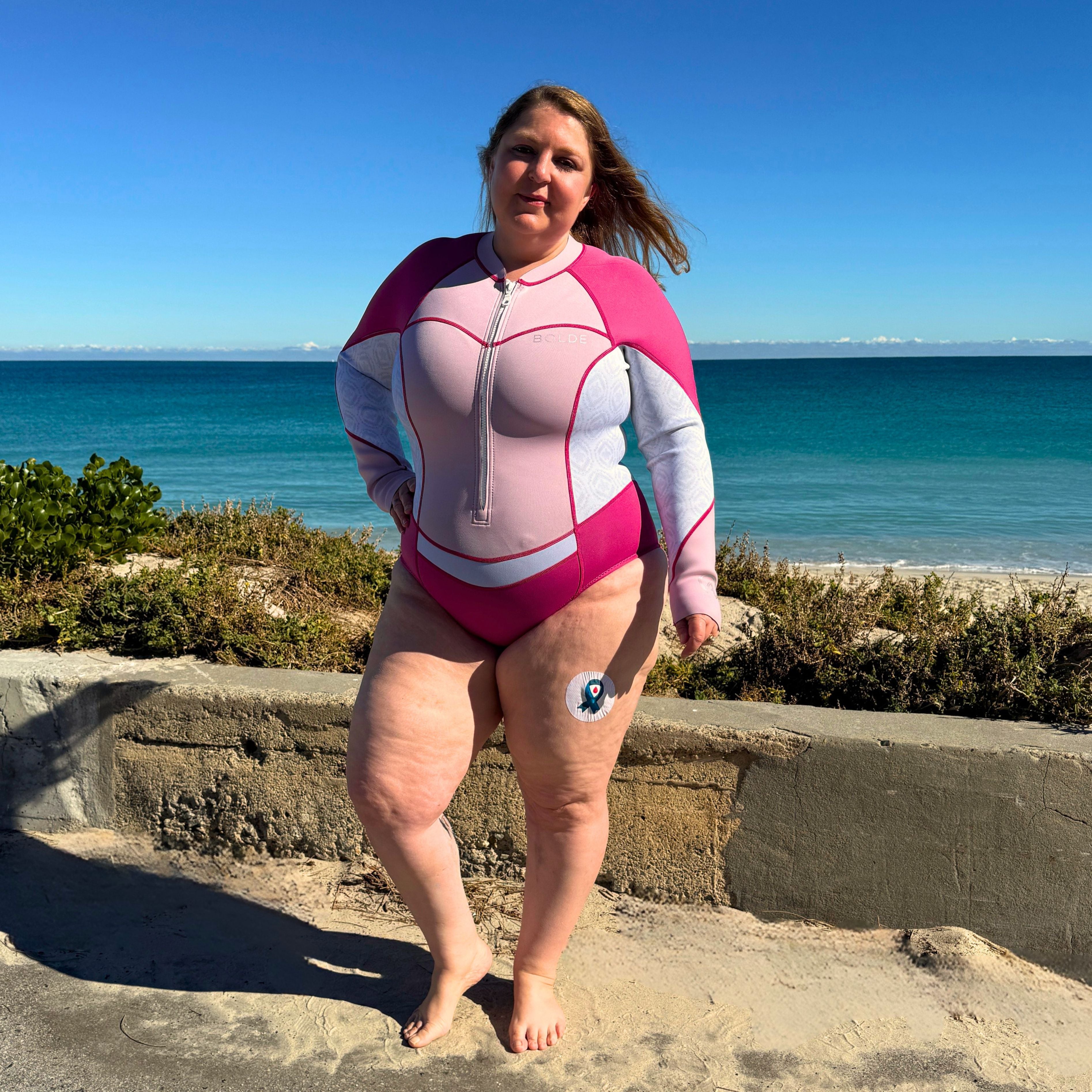 A model wearing a BOLDE Turtle springsuit in pink colour