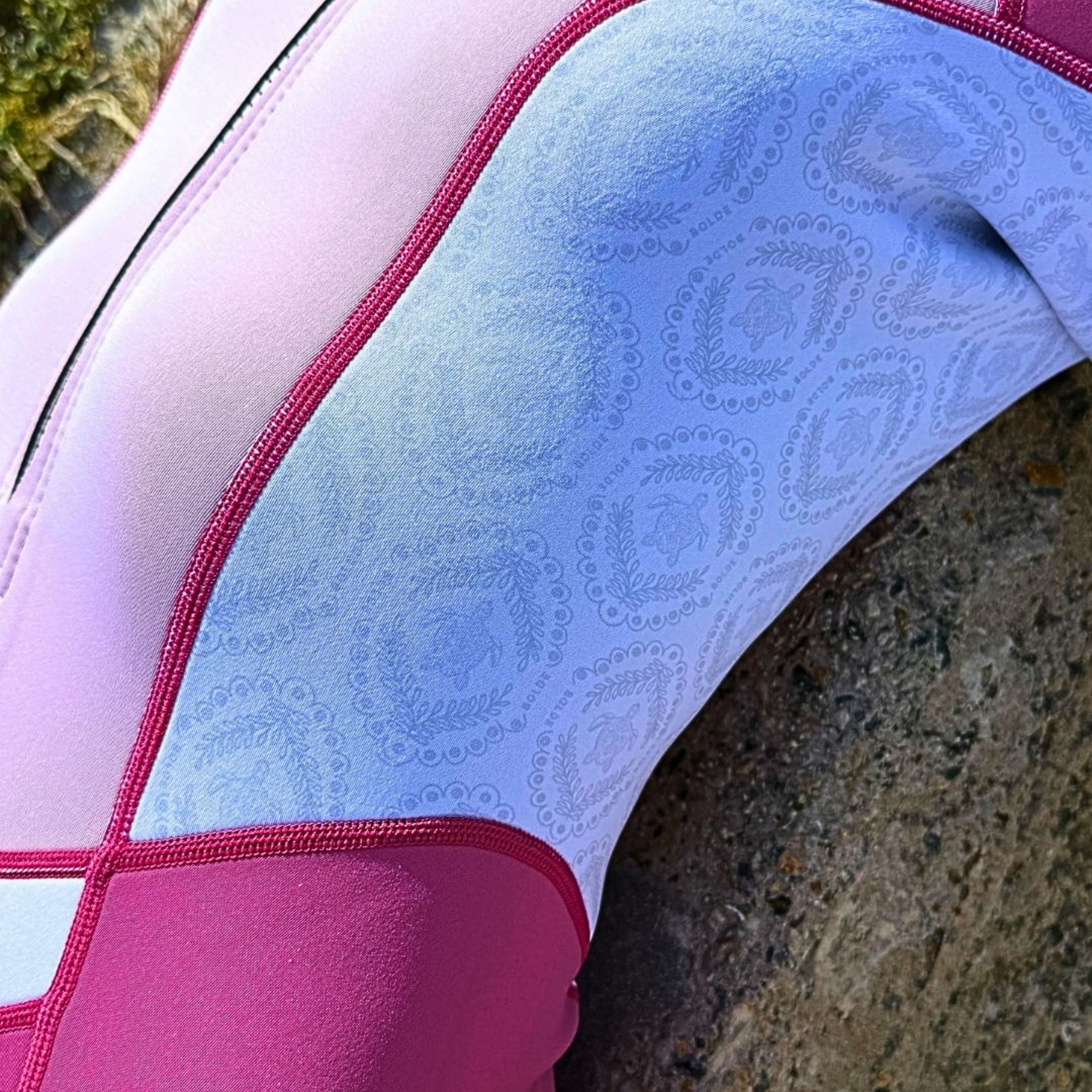 Close-up of a BOLDE Turtle pink springsuit with turtle patterns